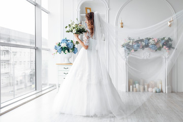 Fototapeta na wymiar Beautiful bride in a wedding dress with lace, posing in the Studio