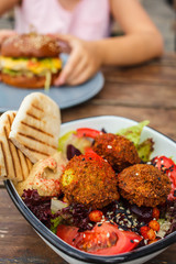 Israeli street food. Falafel salad with hummus, beetroot and vegetables in bowl in a restaurant.