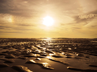 Obraz premium Golden sand ripples surface pattern on sunset beach.