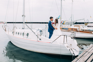 Wedding couple on the yacht, lovers posing on the yacht
