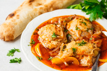 Georgian traditional chicken chakhokhbili in a white plate.