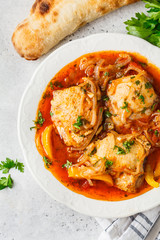 Georgian traditional chicken chakhokhbili in a white plate.
