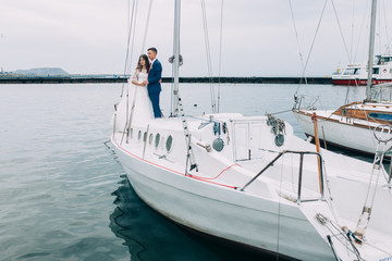 Wedding couple on the yacht, lovers posing on the yacht