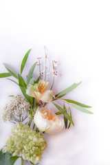 Vertical image of fresh cut flowers and greenery on a white background with copy space