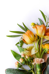 Vertical image of fresh cut flowers and greenery on a white background with copy space