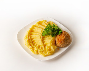 02 Chicken cutlet with mashed potatoes decorated with sprigs of parsley and dill on a white background