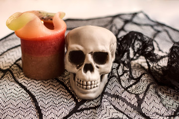Halloween skull with a lit candle on a cobweb texture background