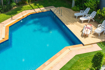 Luxury pool of apartments with sunbathing, green areas with grass and small trees,Top eye view