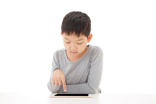Asian boy using tablet computer isolated on white background.