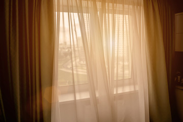 window is open in house, evening light fills room of apartment, bright ray of sun shines through...