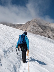 Fototapeta na wymiar homme grimpant la montagne en alpinisme sur neige et glacier