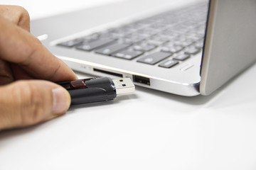 hand man hold Flash drive connect to USB port plug-in computer laptop for transfer data and backup business concept 