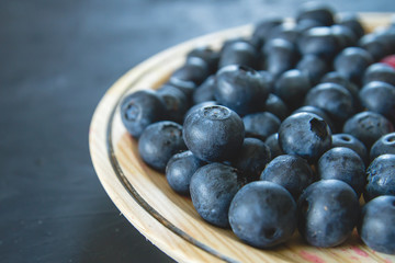Detail of fresh blueberries on a wooden dish