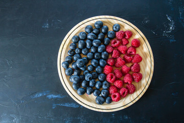 Blueberries and raspberries on a wooden dish