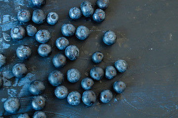 Fresh wild hand-picked blueberries on a dark wooden table