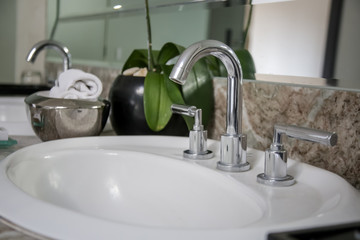 Modern bathroom interior. White washbasin sink and chrome faucet