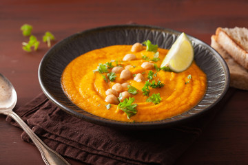 creamy carrot chickpea soup on dark rustic background