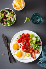 healthy keto diet breakfast: egg, tomatoes, salad leaves and bacon