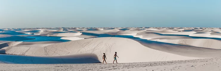 Papier Peint photo autocollant Brésil voyage en couple traversant des dunes de sable géantes avec des lagons à Lencois Maranhenses, l& 39 une des attractions touristiques les plus étonnantes du nord-est du Brésil