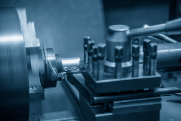 The lathe machine  rough cutting the metal shaft. The metal working processing by turning machine .