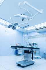 Surgical lamps in operating room and modern equipment at hospital.Medical device for surgeon surgical emergency patient in blue tone style.Save life medical treatment concept.