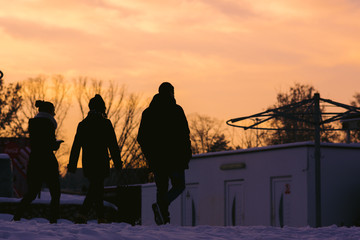 silhouettes of 3 people at sunset
