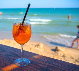 Cocktail aperol-spritz over the sea background. Summer time.