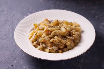 Fried potatoes with onions and seasonings on a white plate