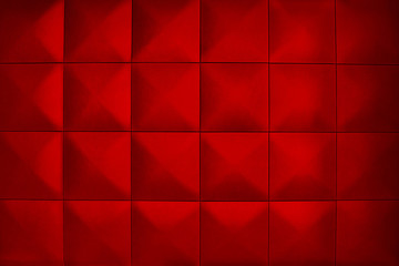 Rhombic red color wall of big squares. Background consists of large red squares. Unusual, beautiful and modern background.