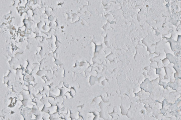 Background of old wall with white peeling paint. Cracked painting of the old surface. Mangy paint with dirty marks on the concrete.