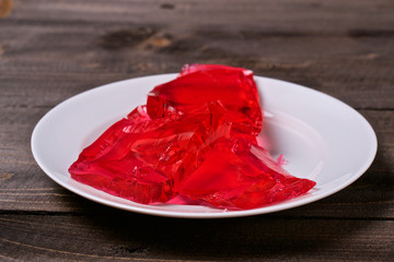 Berry jelly in a white plate on a wooden table