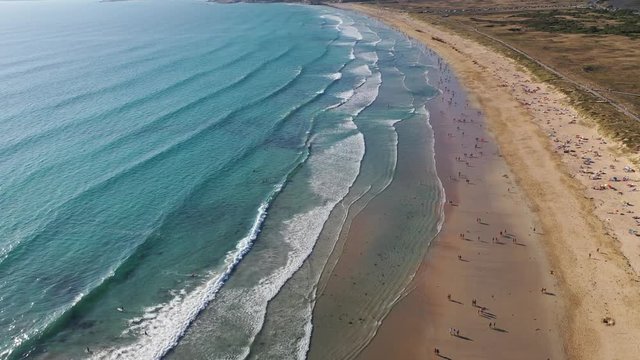 ocean waves sandy beach with people bathing in the water view from drone Lanzada beach Galicia Spain 4k video