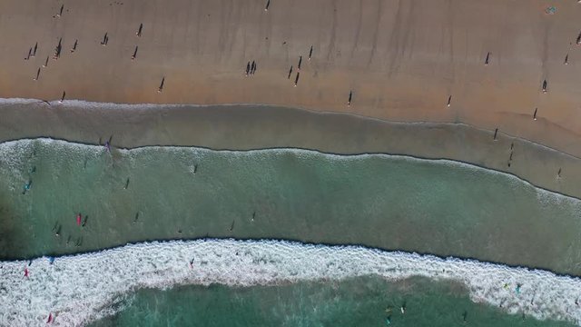 ocean waves sandy beach with people bathing in the water view from drone Lanzada beach Galicia Spain 4k video