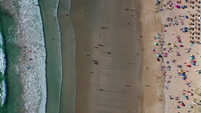 ocean waves sandy beach with people bathing in the water view from drone Lanzada beach Galicia Spain 4k video