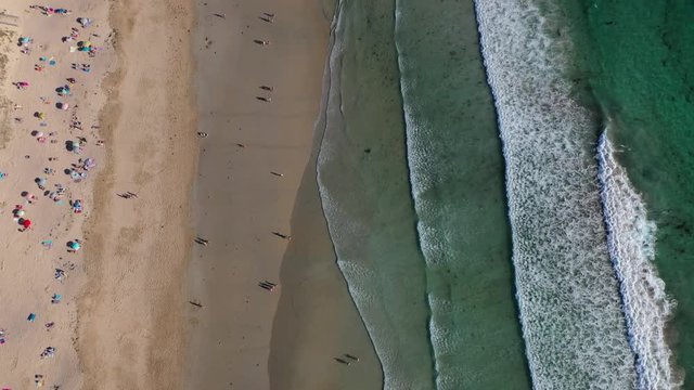 ocean waves sandy beach with people bathing in the water view from drone Lanzada beach Galicia Spain 4k video