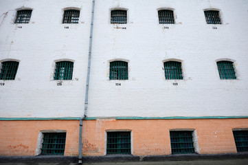 Wall of a prison, windows with bars. Detention facility