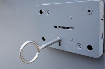 Lock on a metal door of a cell, a key placed in keyhole of a lock