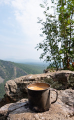 Coffee in a metal mug brewed on a fire in nature in the mountains. Coffee in nature