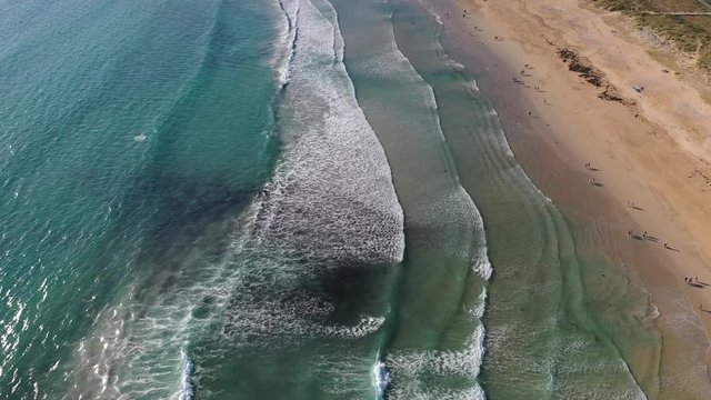 ocean waves sandy beach with people bathing in the water view from drone Lanzada beach Galicia Spain 4k video