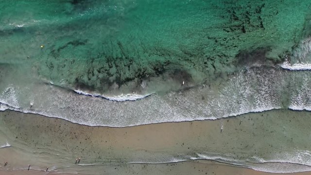 ocean waves sandy beach with people bathing in the water view from drone Lanzada beach Galicia Spain 4k video