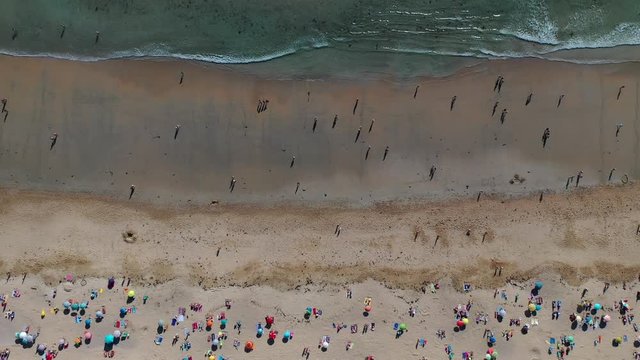ocean waves sandy beach with people bathing in the water view from drone Lanzada beach Galicia Spain 4k video