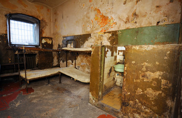 In the Ukrainian prison. Part of an old cell with bunks and mattresses, bars on a window, toilet