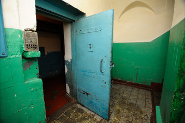 Part of prison hallway, bars, door opened of the detention facility (SIZO). 