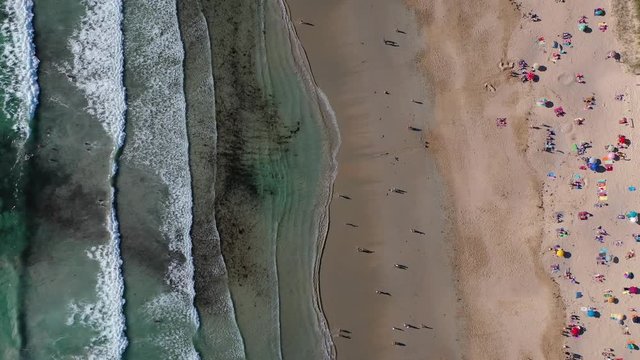 ocean waves sandy beach with people bathing in the water view from drone Lanzada beach Galicia Spain 4k video