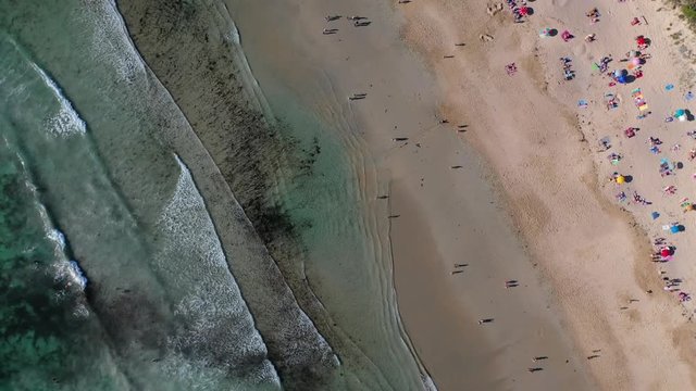 ocean waves sandy beach with people bathing in the water view from drone Lanzada beach Galicia Spain 4k video