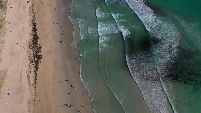 ocean waves sandy beach with people bathing in the water view from drone Lanzada beach Galicia Spain 4k video