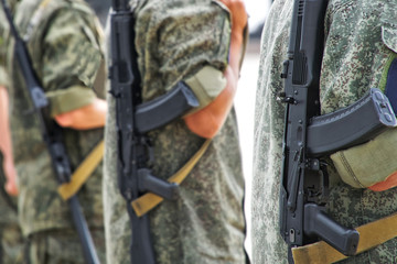 Man with machine guns in protective khaki clothes in the streets of the city. Patrol or security