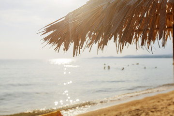 Fototapeta na wymiar Straw sunshade on the sand beach Summer Vacation