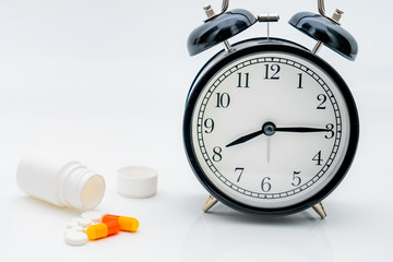 Pills, capsules, bottles and alarm clock