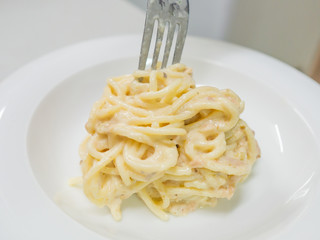 Pasta Carbonara with tuna on a white plate